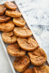 Plate with tasty dried figs on table
