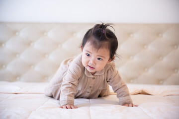 Fototapeta premium Portrait of a baby girl on the bed in bedroom