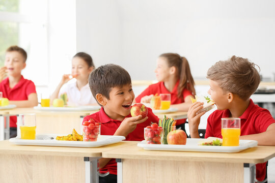 Pupils having healthy lunch in classroom