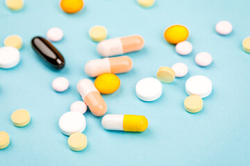 A bunch of pills on a blue background. The concept of healthcare