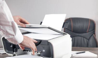 Man copying and scanning documents in office.
