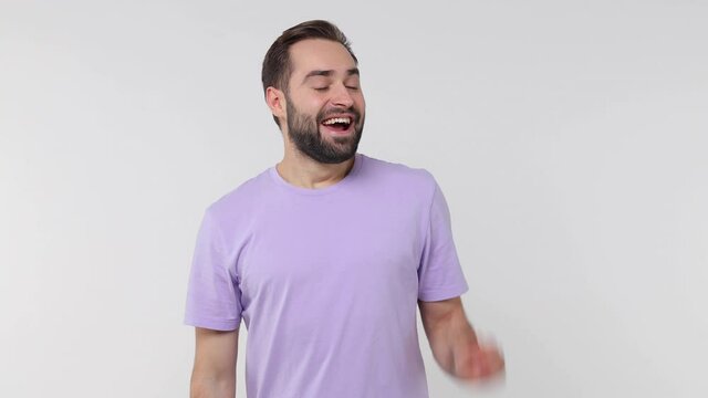 Cheerful funny bearded young man 20s years old in pastel casual violet t-shirt isolated on white color wall background studio. People lifestyle concept. Looking aside scream news with hands near mouth