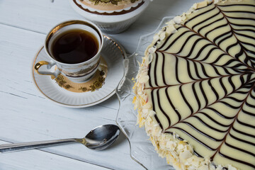 Cup of tea and esterhazy cake on a light background