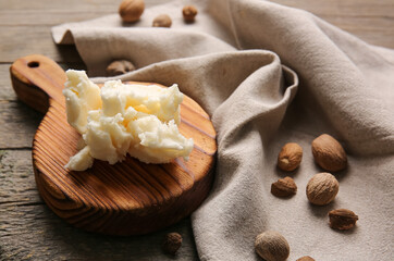 Board with shea butter on wooden background
