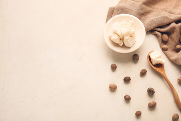 Shea butter with nuts on light background