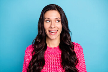 Portrait of attractive cheerful wavy-haired girl licking lip looking aside copy space isolated over bright blue color background