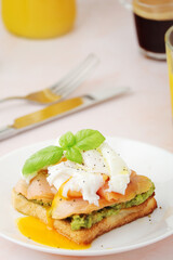 Breakfast with a sandwich with poached egg and avocado