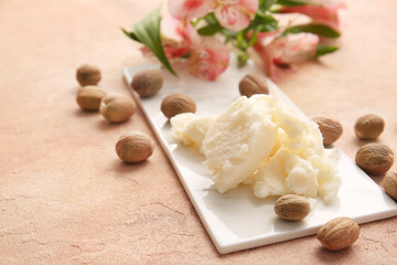 Fototapeta na wymiar Shea butter with nuts on color background