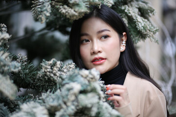 Portrait of young beautiful woman in winter clothes. while posing on snow background. Outdoor close-up photo of female model with romantic smile chilling in park in winter.