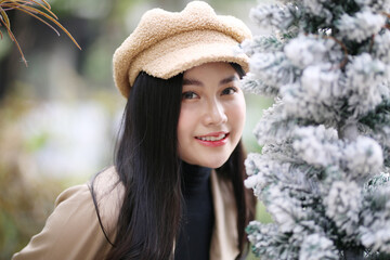 Portrait of young beautiful woman in winter clothes. while posing on snow background. Outdoor close-up photo of caucasian female model with romantic smile chilling in park in winter.