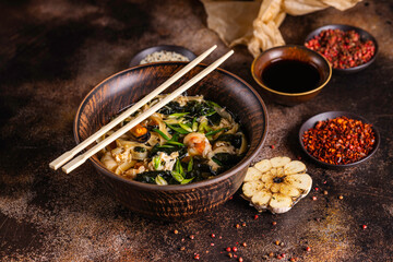 Asian style soup with udon noodles and seafood. Delicious scene.