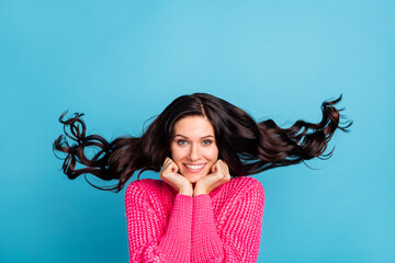 Photo of cute cheerful lady arms on cheeks beaming smile hair flying isolated on blue color...