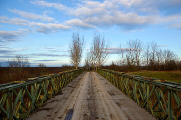 old rusty bridge with blue sky and white clouds