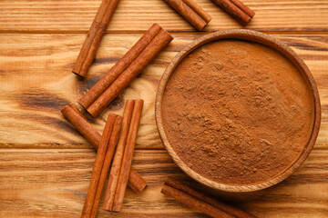 Fototapeta na wymiar Cinnamon sticks and powder on wooden background