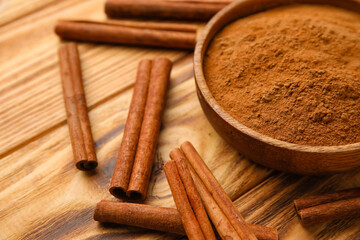 Cinnamon sticks and powder on wooden background