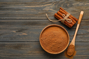 Cinnamon sticks and powder on wooden background