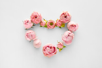 Heart made of beautiful flowers on light background