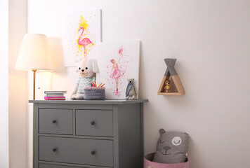 Chest of drawers and beautiful pictures in children's room. Interior design