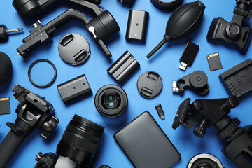 Flat lay composition with camera and video production equipment on blue background