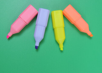 Multi colored highlighters pens  on Green Background or Wallpaper Copy Space  Top View, teamwork concept