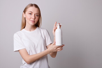 girl with reusable container for cosmetics in her hands on a gray background