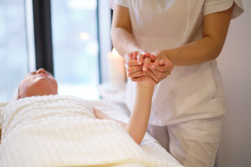 Wrist massage. massage therapist puts pressure on a sensitive point on a woman's hand....