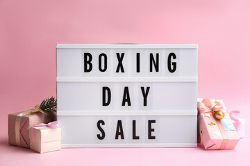 Lightbox with phrase BOXING DAY SALE and Christmas decorations on light pink background