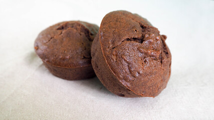 two gluten-free chocolate muffins on a white background side view, cooked at home