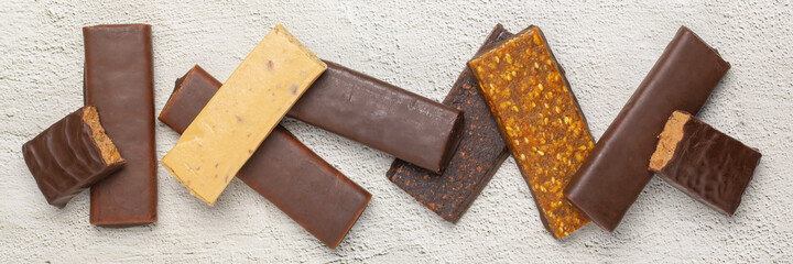 Different energy protein bar on grey background.