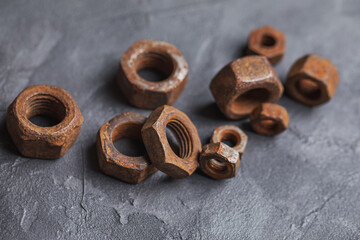 Old rusty nuts on a dark gray background. Parts of industrial machines. Horizontal photo.