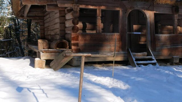 Decorative handmade weather vane near rural wooden house in snowy winter mountains forest. Ski resort family active rest. Snowy winter holidays. Weather aerovane, wind vane or weathercock instrument.