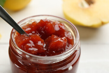 Delicious quince jam on white table, closeup