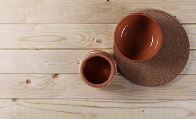 Clean and empty bowls on wooden plank table with cork coaster, plug, boards surface background and texture, top view