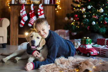 boy hugging dog in christmas decor