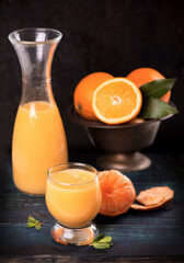 glass of fresh orange juice with fresh fruits on wooden