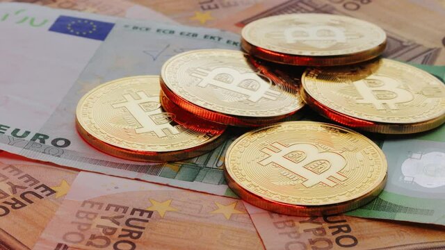 Euro bills. Rotation Coin with symbol of cryptocurrency of bitcoin lies on real banknotes of European Union, euro, new money, exchange of digital money for euro, gold coin, new economy. Euro banknotes