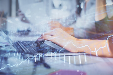 Multi exposure of woman hands typing on computer and financial graph hologram drawing. Stock market analysis concept.