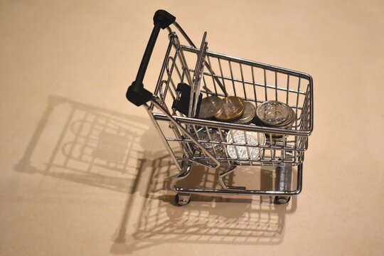 Shopping Cart Full Of Coins, Concept To Illustrate Current Crisis Or Deployment Of An Incentive Program For Loyal Customers.