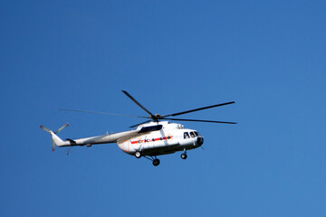 Fototapeta na wymiar Red rescue helicopter moving in blue sky with blur propeller .
