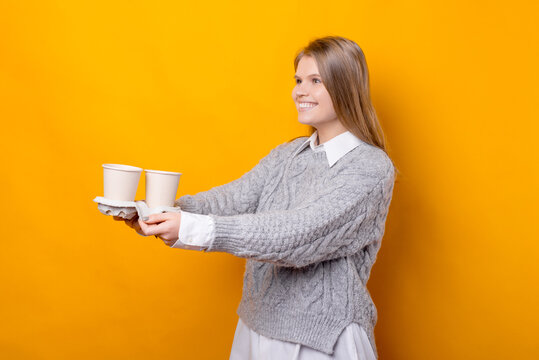 Photo Of Cheerful Young Woman Giving Some Cups Of Coffee To Go.