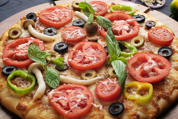 Pizza with tomato,olives and mushroom. Italian cuisine. Ingredients for making pizza on a black background Top view.Concept for advertising restaurants or pizzerias.