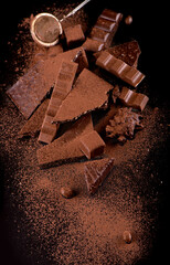 chocolate pieces and cocoa powder on wooden background