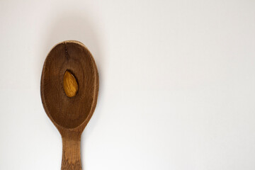 almond in spoon on white isolated background with copy space