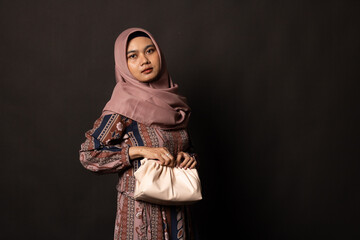 Beautiful stylish girl holding bag on black background