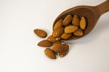 nuts in spoon on white isolated background with copy space