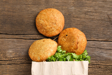 Kachori and coriander on wooden background.kachori is a spicy snack from India also spelled as kachauri and kachodi. Served with tomato ketchup. Favorite Tea time snacks