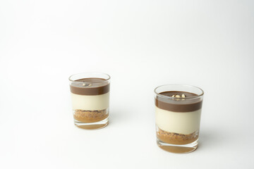 Two chocolate dessert in glass (yogurt or cream, cookies and nuts ).Candies sweet concept isolated on white background.