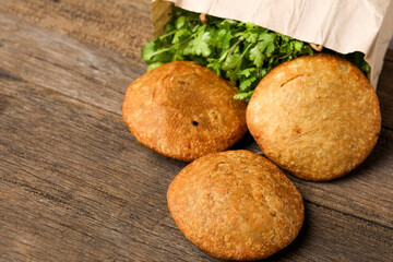 Kachori and coriander on wooden background.kachori is a spicy snack from India also spelled as kachauri and kachodi. Served with tomato ketchup. Favorite Tea time snacks