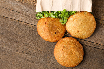 Kachori and coriander on wooden background.kachori is a spicy snack from India also spelled as kachauri and kachodi. Served with tomato ketchup. Favorite Tea time snacks