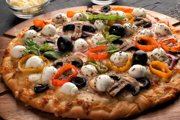 Pizza with mozzarella ,olives and mushroom. Italian cuisine. Ingredients for making pizza on a black background. Top view.Concept for advertising restaurants or pizzerias.
